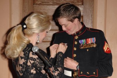 Patricia Kennedy, pins Peace One Earth Medallion on USMC Cpl. Aaron Mankin Photo