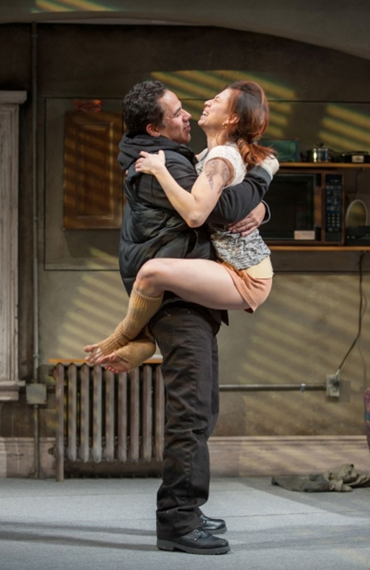 Veronica (Sandra Delgado) leaps into Jackie's (John Ortiz) arms when he tells her that he found a job at 