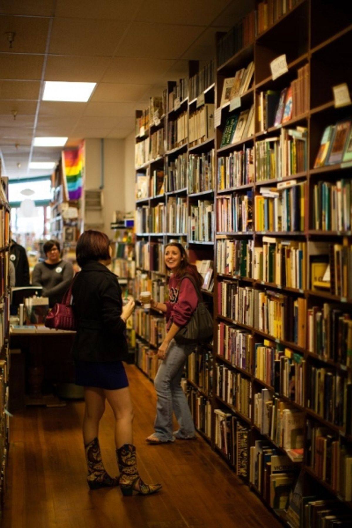 Audiences watch Whitney Shay as Chris and Kathryn Byrd as Alex among the stacks of books. at 
