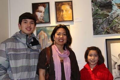 Painter Mic Boekelmann, center, of Princeton, is pictured with her paintings and her  Photo