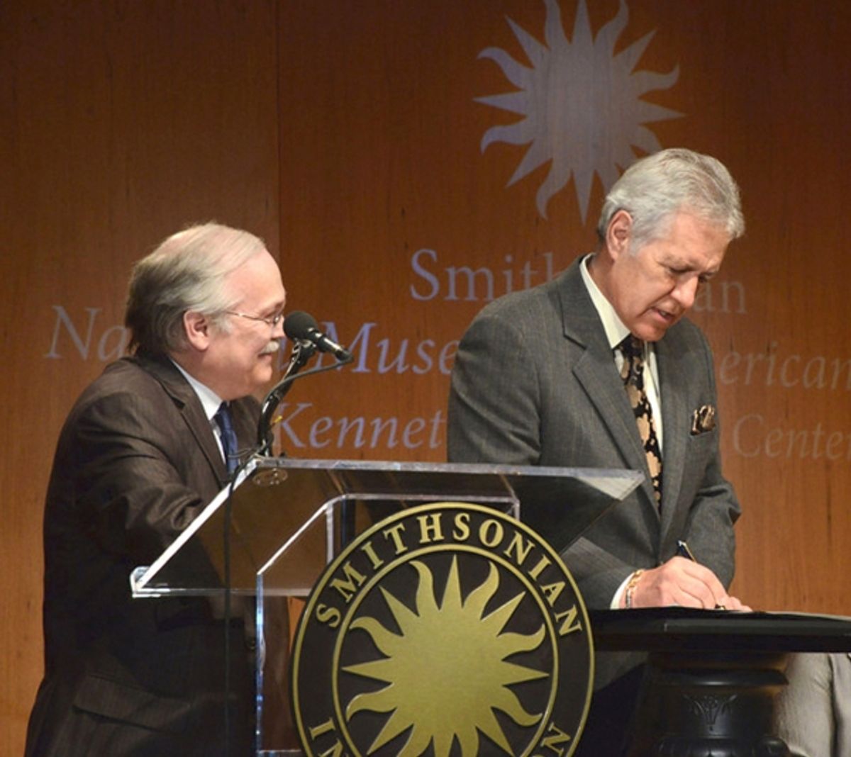 Dwight Bowers looks on as Alex Trebek signs his Deed of Gift at 