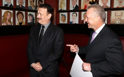 Tom Hanks with wife Rita Wilson caricature behind him Photo