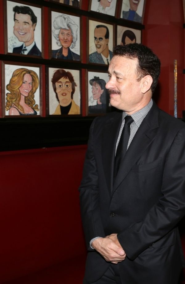 Tom Hanks with wife Rita Wilson caricature behind him Photo