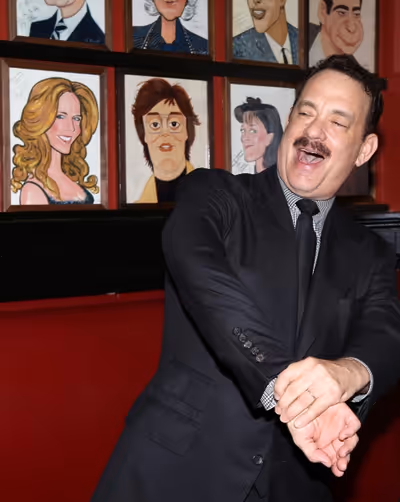 Tom Hanks with wife Rita Wilson caricature behind him Photo