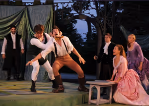 (front, center) Benjamin Stirling as Charles, a champion wrestler takes on Orlando played by Matthew Simpson while (l to r) Rosalind played by Caralyn Kozlowski and Celia played by Maria Tholl look on. @ BroadwayWorld (front, center) Benjamin Stirling as Charles, a champion wrestler takes on Orlando pl Photo
