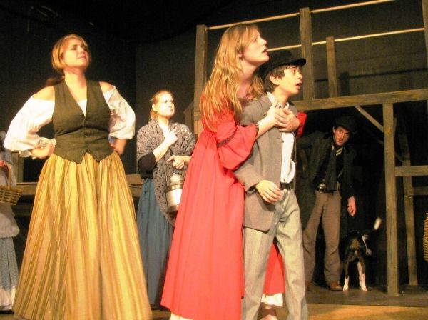 Nancy (Tess Ammerman, center) embraces Oliver (Adam Juraga), pretending the boy is a  Photo