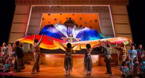 The cast and children''s chorus surround Joseph (Ryan Michael Crimmins) and his technicolor dreamcoat. (Alex Ohmart, India Chudnow, Tristan Klaphake, Morgan Goldberg, Trisha Hart Ditsworth, Laura Berger, Kyshawn Lane, Joey Donnelly, Chica Loya, Ryan Micha @ BroadwayWorld The cast and children''s chorus surround Joseph (Ryan Michael Crimmins) and his techn Photo