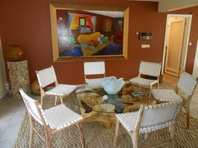 Dining area staged by Ernie J. Hulse beneath a painting by Scott Benjamin Tucker Photo