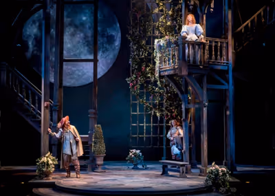 Cyrano (Harry Groener) masquerading as the tongue-tied Christian (Nick Dillenburg) to Photo