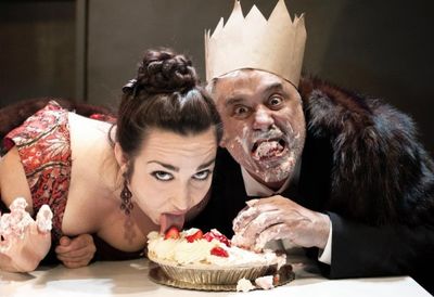 The gluttonous Mother (Ponder Goddard) and Father Ubu (David Sinako) over-indulge in  Photo
