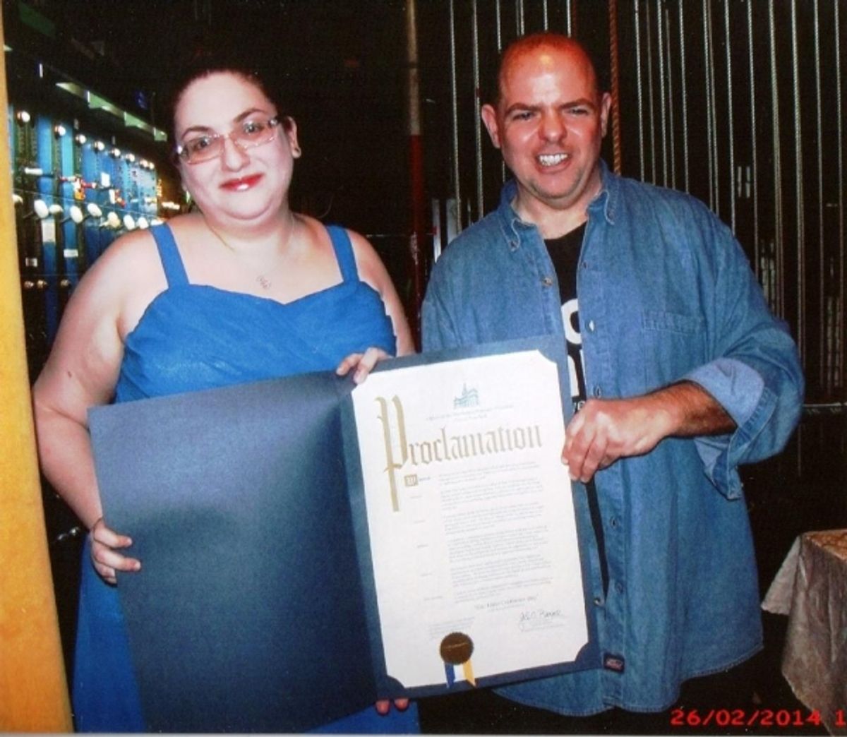 No Name Comedy / Variety Show  co-founder / producer Eric Vetter (right) and his stage manager (Super) Shani Lieberman(left) display a proclamation prepared by the office of the Manhattan Borough President Gale A. Brewer  in recognition of  No Name''s 20t at 