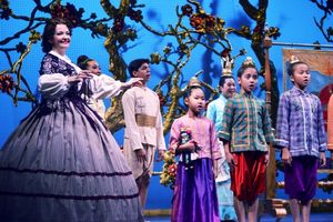 Michele Ragusa (as British schoolteacher Anna Leonowens), left, leads her pupils in song @ BroadwayWorld Michele Ragusa (as British schoolteacher Anna Leonowens), left, leads her pupils in s Photo