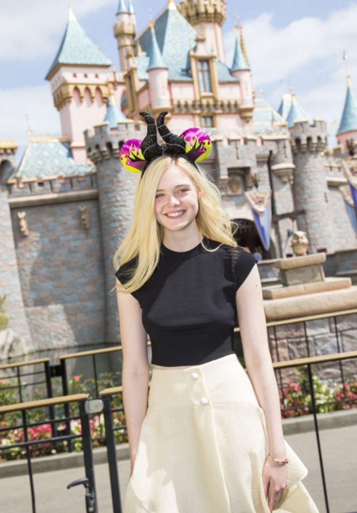 Elle Fanning poses at Sleeping Beauty Castle at Disneyland at 