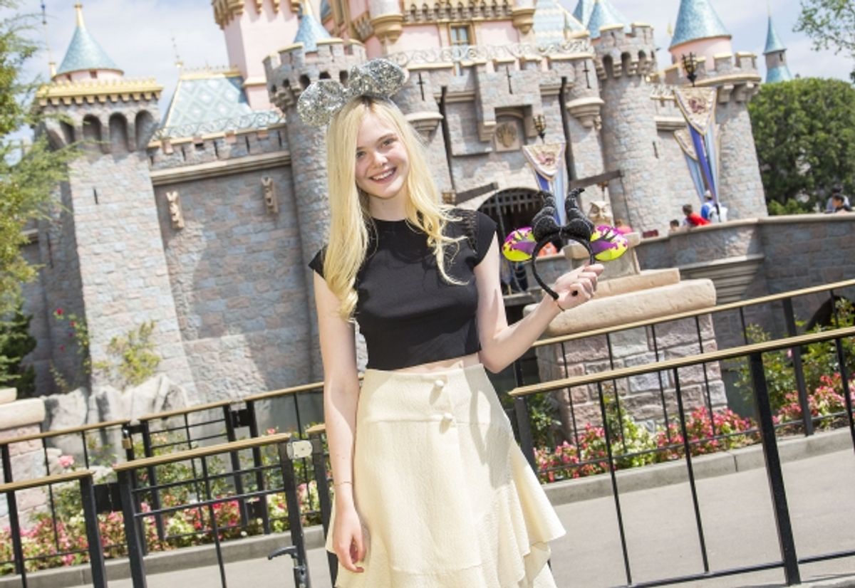 Elle Fanning poses at Sleeping Beauty Castle at Disneyland at 
