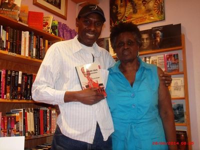 Author and Comedybeat.org managing editor Carl Unegbu greets Sisters Uptown Bookstore Photo