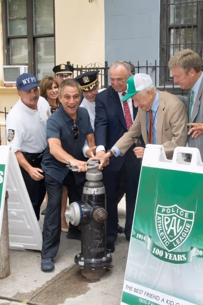New PAL Board Member Tony Danza opens a fire hydrant for NYC youth to cool off under  Photo