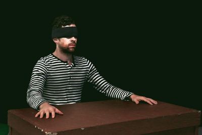 Katurian (Aaron Echegaray) awaits his interrogation. Photo