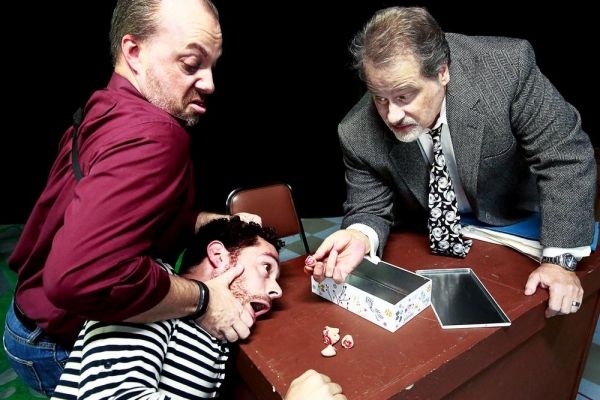 The detectives (Trevor B. Cone, Scott Holmes) show Katurian (Aaron Echegaray) the evi Photo