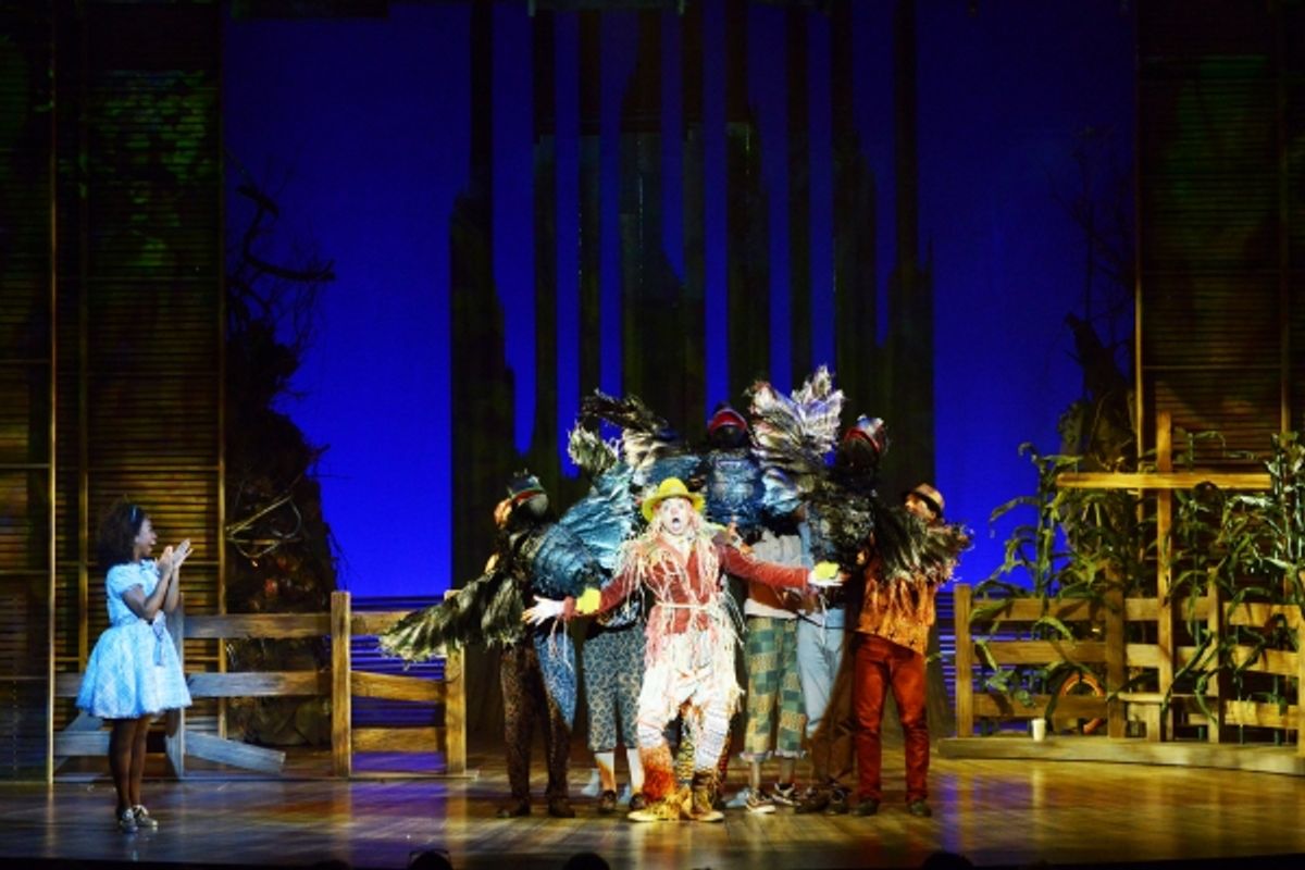 Dorothy (Destinee Rea), left, watches as the Scarecrow (David LaMarr, center) sings and dances with crows (puppets controlled and voiced by members of the cast)  at 