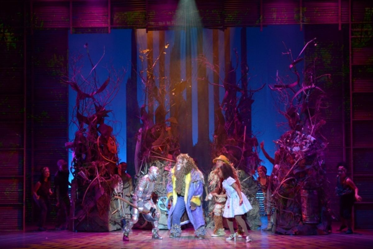 The Tinman (Tyrick Wiltez Jones), the Lion (Trevor Dion Nicholas), the Scarecrow (David LaMarr) and Dorothy (Destinee Rea) make their way through the forest  at 