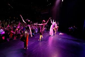 Dame Edna and the cast throw gladiolas to the audience Photo