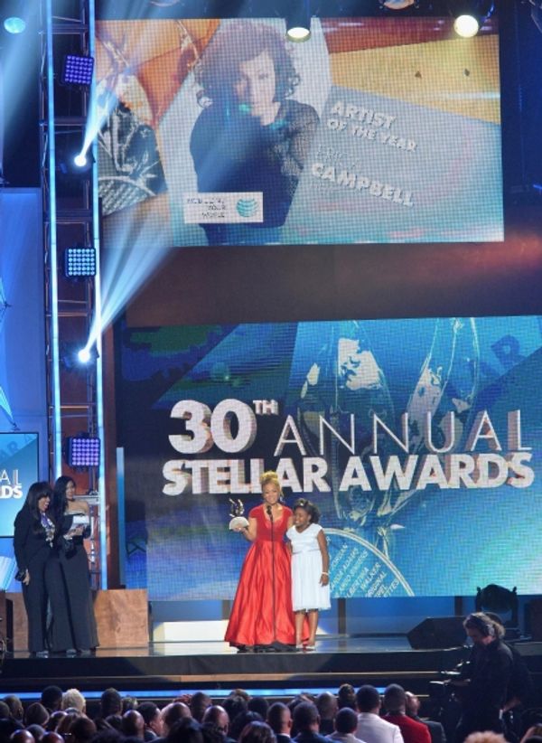 Singer Erica Campbell accepts an award onstage Photo