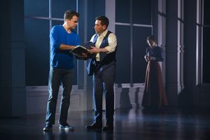 Brian (Ross Lekites) explains the connection they share with the Triangle Shirtwaist Factory to Ben (Zachary Prince) as a vision of Sarah (Megan McGinnis) lingers in the background @ BroadwayWorld Brian (Ross Lekites) explains the connection they share with the Triangle Shirtwaist Photo