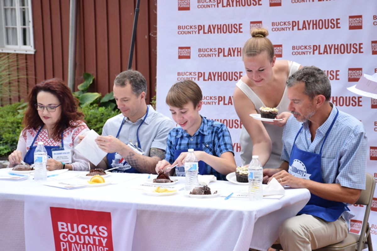 Abby Langsted, Bucks County Playhouse Marketing Manager (standing), brings cupcakes to be judged to the judges: (from left) Cast Members: Michele Ragusa, Euan Morton, Aidan J. Lawrence (14 years old) and Bucks County Playhouse Producing Director Alex Fras at 