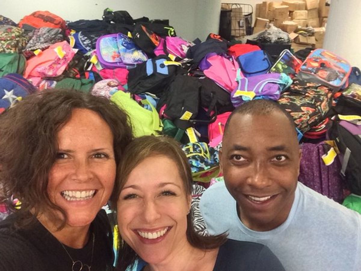 Volunteers persona; chef Lisa Adams, actress Paige Davis, and director/choreographer Christopher Windom help fill backpacks. at 