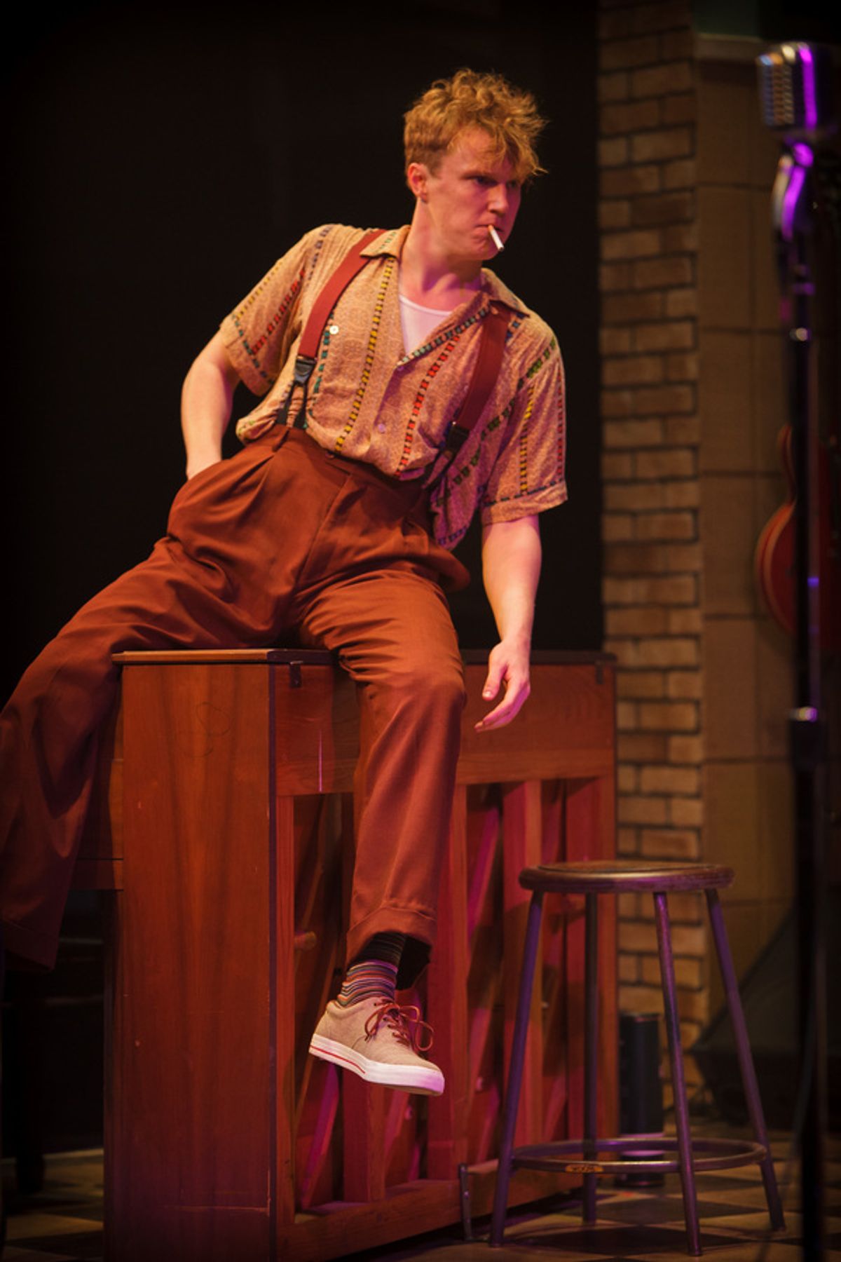 Jerry Lee Lewis (Noel Carey) sits astride his instrument for a smoke break  at 