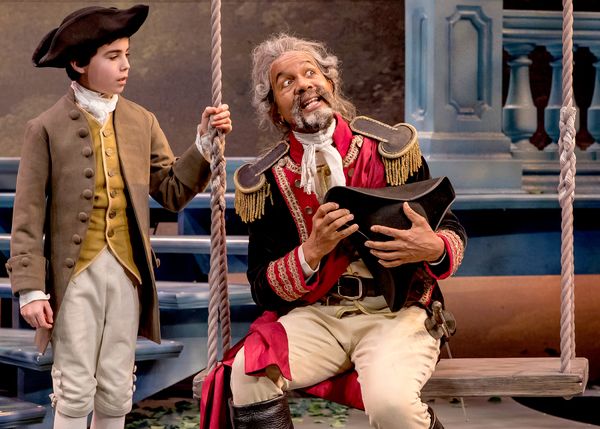 The long-winded Don Armado (Allen Gilmore) regales his young page Moth (Aaron Lamm) w Photo
