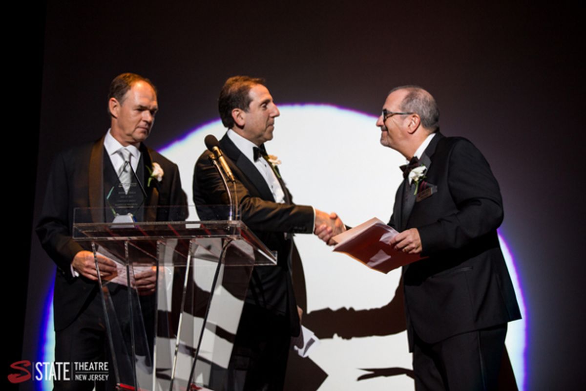 Principal Jeffrey Jones and Managing Director and Chief Operating Officer Craig Guiffre from American Benefits Consulting accept their award on stage at State Theatre New Jersey from State Theatre New Jersey President & CEO Tom Carto. at 