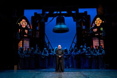 Dom Claude Frollo (Tom Ford*) is an imposing figure before his congregation with the  Photo