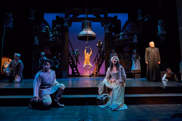 Quasimodo (Corey Mach*) rings the bells of Notre Dame while sheltering Phoebus (Jon H Photo