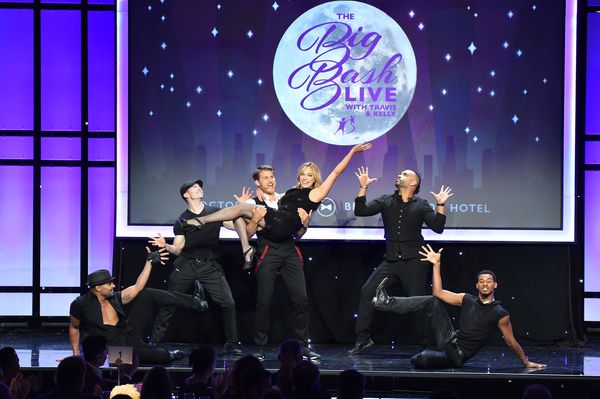 Travis Van Winkle holding Big Sister Kelly Sullivan (center) on stage with dancers Photo