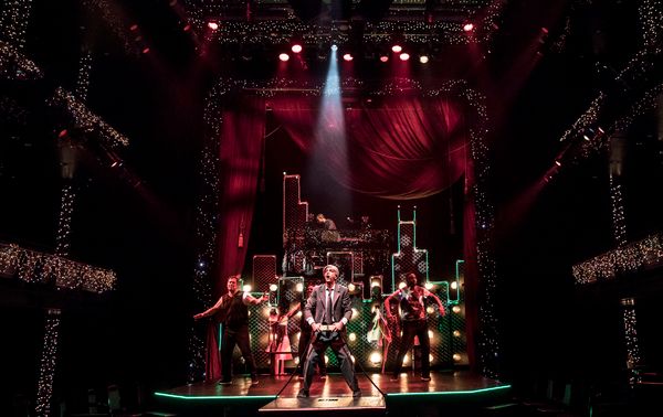 Scrooge (GQ, at center) embraces the magic of the Christmas season with the cast of C Photo