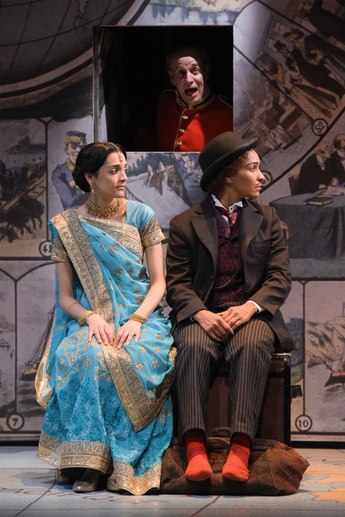 L-R: Princess Aouda (Ajna Jai), and Passepartout (Tristan Cunningham) hear an announcement from the train conductor (Ron Campbell) in TheatreWorks Silicon Valley's Around the World in 80 Days. The hilarious holiday adventure adapted by Mark Brown from the at 