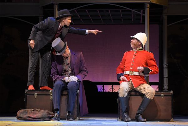 L-R: Passepartout (Tristan Cunningham) stands up to Sir Francis (Ron Campbell) while  Photo