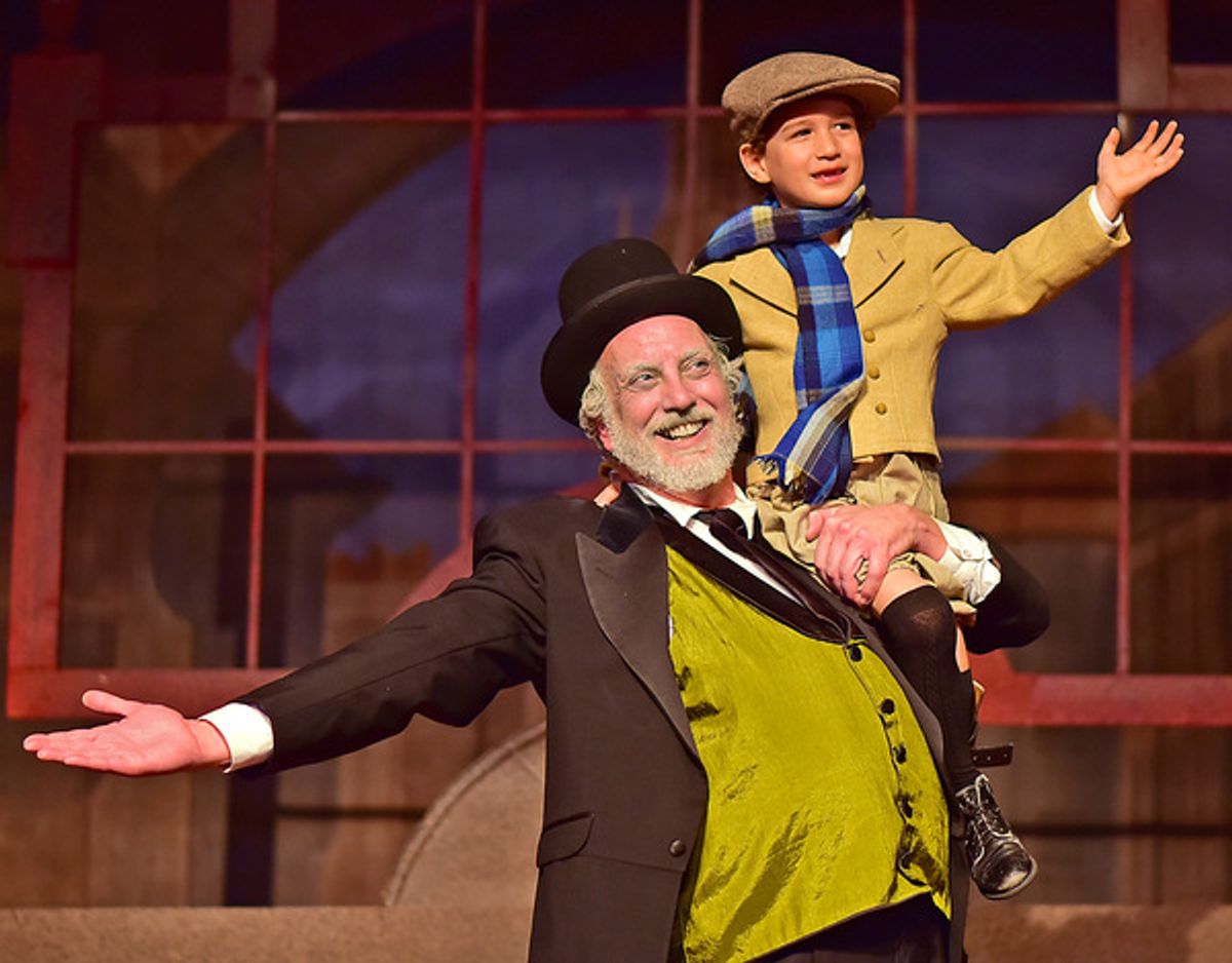 Ebenezer Scrooge (Jeff Stockberger) lifts Tiny Tim (Ashton Curry) at 