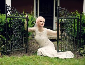 Doreen Taylor kneels at the original gate to the formal front door to Highland Farm,  Photo