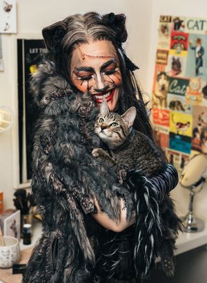 Mamie Parris of the CATS cast and an adoptable shelter cat share a moment backstage Photo