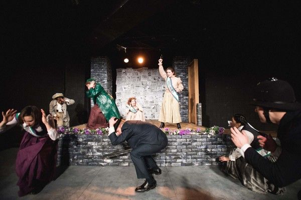 Hilda fires a gun to drive back the arresting officers at Emmeline Pankhurst's Glasgo Photo