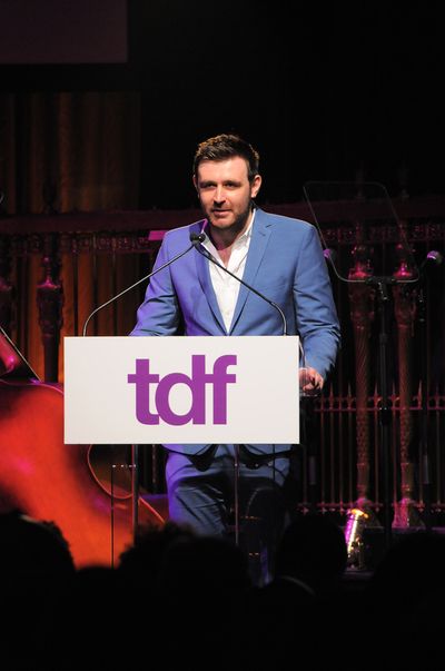 James McArdle at podium introducing Tony Kushner Photo