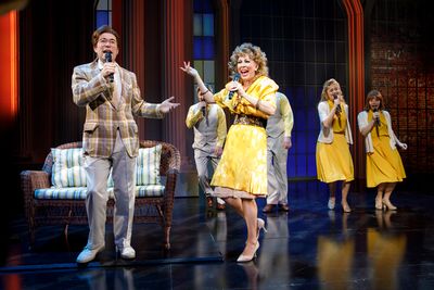 Chaz Pofahl as Jim Bakker and Kirsten Wyatt as Tammy Faye Bakker, with members of the Photo
