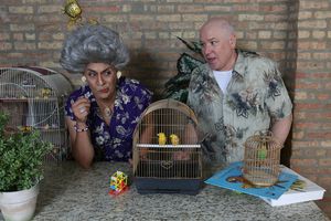Mother Nurdiger (David Cerda) and her loyal son, Chester Nurdiger (Ed Jones), inspect the new shipment of songbirds in a publicity image for Hell in a Handbag Productions’ comedy THE ARTIFICIAL JUNGLE. @ BroadwayWorld Mother Nurdiger (David Cerda) and her loyal son, Chester Nurdiger (Ed Jones), inspect Photo