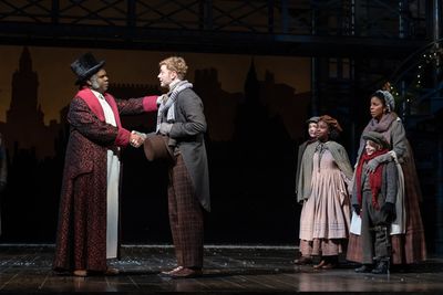 Craig Wallace as Ebenezer Scrooge, Gregory Maheu as Bob Cratchit, Yesenia Iglesias as Photo