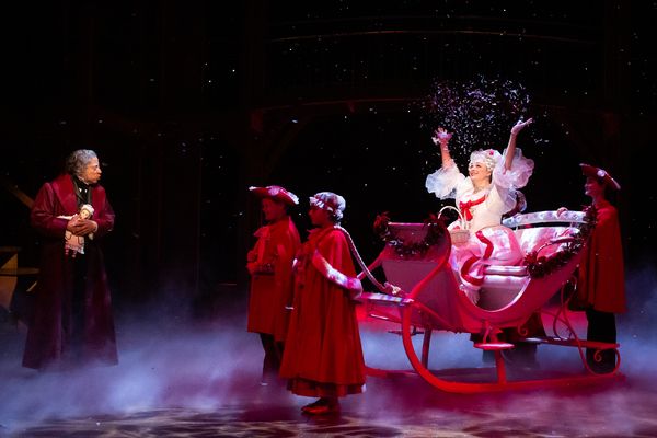 David Rainey as Scrooge and Melissa Pritchett as Spirit of Christmas Past with Compan Photo