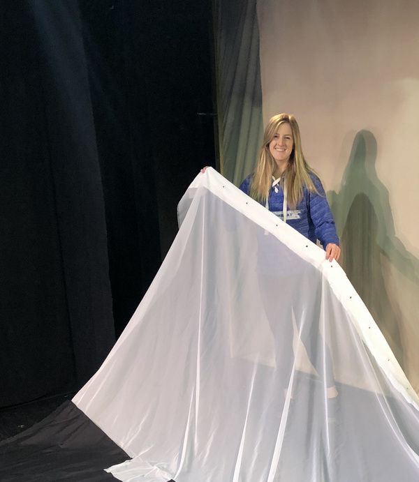 Creator Jacklyn Thrapp getting ready to hang a curtain. Photo
