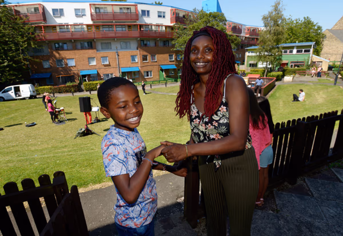 Byker estate residents Damereo and his mum, Lucy Stobbart enjoy live music from their doorstep. Photo credit: North News at Northern Stage Brings Music to People's Doorsteps