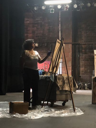 The artist Cara London, painting on the stage of the empty Park Theatre. 

 Photo
